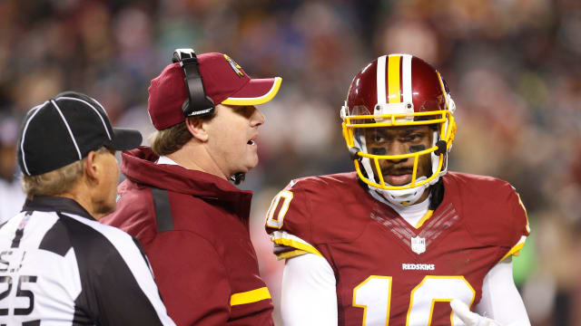 Washington Redskins head coach Jay Gruden (C) talks to Redskins quarterback Robert Griffin III (10) in the second half against the Philadelphia Eagles at FedEx Field. The Redskins won 27-24. Mandatory Credit: Geoff Burke-USA TODAY Sports